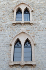 Old Gothic Windows in the shape of a peak in a stone building.