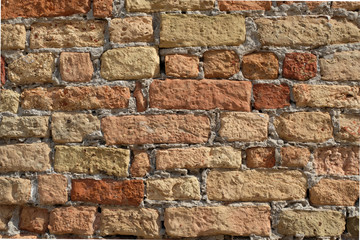 Italian brick wall. Bricks in different shades of red,weathered surface visible grout and mortar.