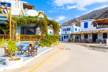 Fototapeta na wymiar Street with traditional Greek houses and tavernas in Finiki port on Karpathos island, Greece