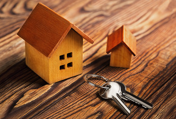 Real  estate concept with small toy wooden  house and key on wooden background. Idea for real...