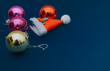 Christmas ornament balls and santa hat on grey background.