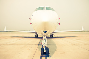 business plane parked at the airport - retro vintage filter effect