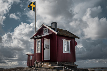 A small hut in front of a Swedish flag
