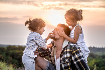 dad playing with two little cute daughters