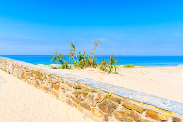 Coastal path along sand dunes and beach in Tarifa town, Spain