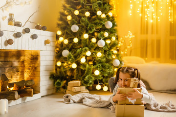 Happy little smiling girl with christmas gift box.