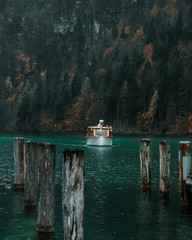 Boot auf dem türkisfarbenen Königssee in Bayern und Herbststimmung