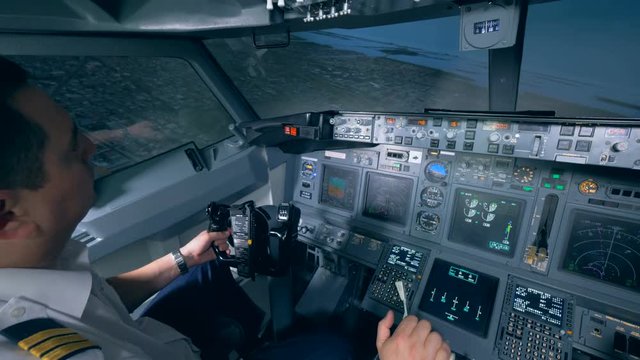 A person holds a steering wheel in a plane simulator, close up.