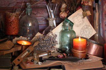 Antique Magic Book. Witchcraft Peacock feathers and candle background. Black candle Magic Ritual.
