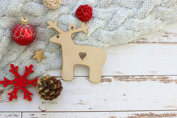 Festive new year background, Christmas. Decorations for the Christmas tree on a white background of old wood. Wooden deer, red ball and snowflake, beautiful scenery.