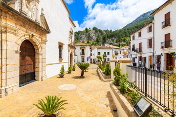 GRAZALEMA, SPAIN - MAY 12, 2018: Church facade and white houses in Grazalema mountain village, Andalusia, Spain. This place is located in National Park and is popular tourist destination.