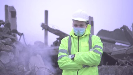 portrait of a rescue worker on the background of the ruins of the house after the earthquake