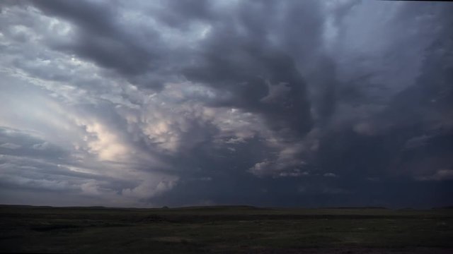 Lighting flashing during thunderstorm over the landscape in the plains at dusk.