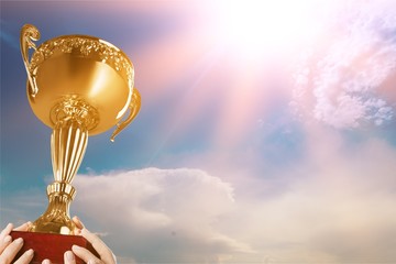 Hands holding golden trophy on a white background