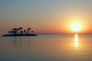 Sunrise over sea with tropical island. Sun rising over ocean