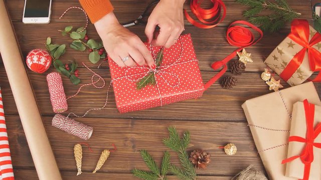 Christmas presents wrapped in eco paper with homemade decoration on wooden background with decor elements and units