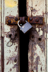 Old wood rural door with rusty padlock