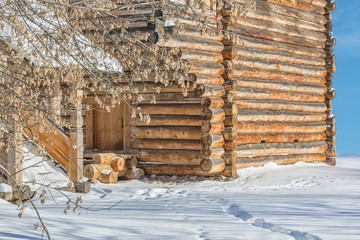Log house on the snow on a winter day