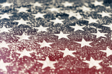 Fototapeta premium Close-up of a grungy print of stars from the american flag with horizontal red light leak. Concept of political division in the United States.