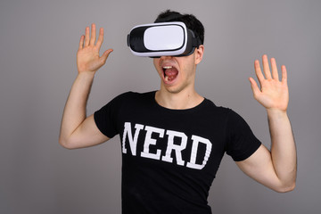 Young handsome nerd man wearing virtual reality headset