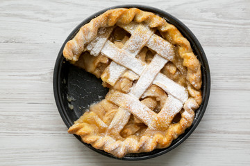 Home-baked apple pie on white wooden background, top view. Flat lay, overhead, from above. Close-up.