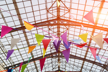 Fototapeta premium Many colorful flags under the openwork metal ceiling. close-up view. concept of holiday mood