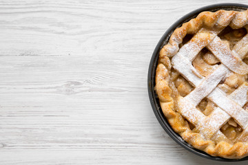 Homemade apple pie on white wooden table, top view. Flat lay, overhead, from above. Copy space.
