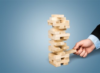 Wood blocks stack game with Hand on background,Conceptual of