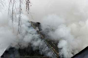 White smoke comes from the burning roof of the house