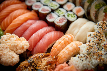 Close up of various types of japanese fresh prepared sushi. Served on a patter with ginger and wasabi.
