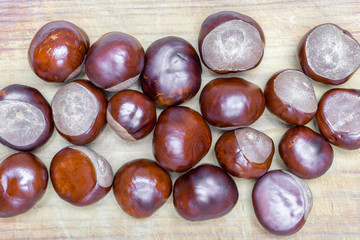 pile of aesculus hippocastanum or conker tree nuts on tablecloth. Closeup, Top view