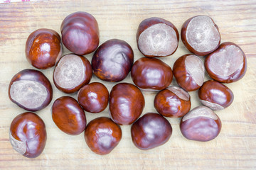 Pile of aesculus hippocastanum or conker tree nuts on tablecloth. Top view. Chestnuts for Christmas