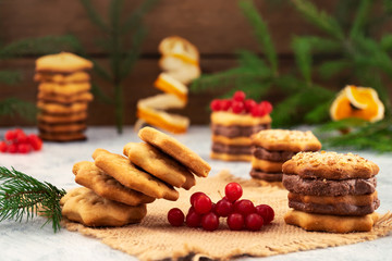 Dessert for the holiday-shaped biscuits falls from the stacked column, layers with chocolate filling, red berries of viburnum, Christmas decorations.