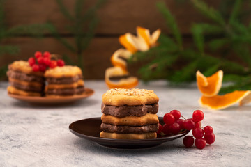 Figured cookies with a layer of chocolate filling with red viburnum berries, Christmas decorations, Christmas card.