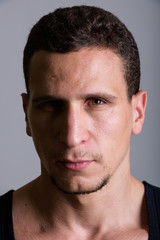 Naklejka premium Face of young muscular Persian man against gray background