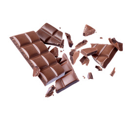 Bar of chocolate is broken into many pieces in the air, isolated on white background
