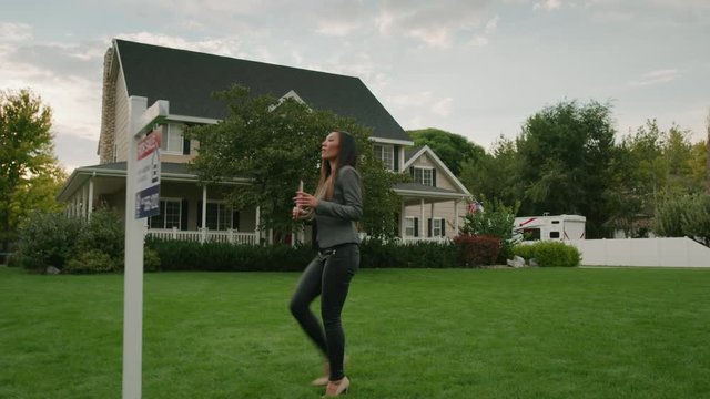 Slow motion tracking shot of realtor placing sold sign on post of house for sale / Pleasant Grove, Utah, United States