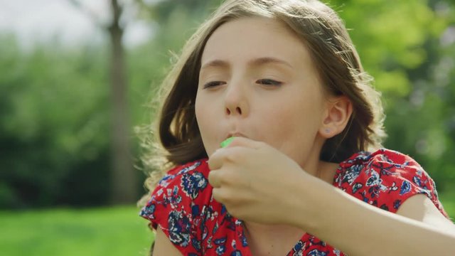 Close up of girl eating green flavored ice treat  / Pleasant Grove, Utah, United States