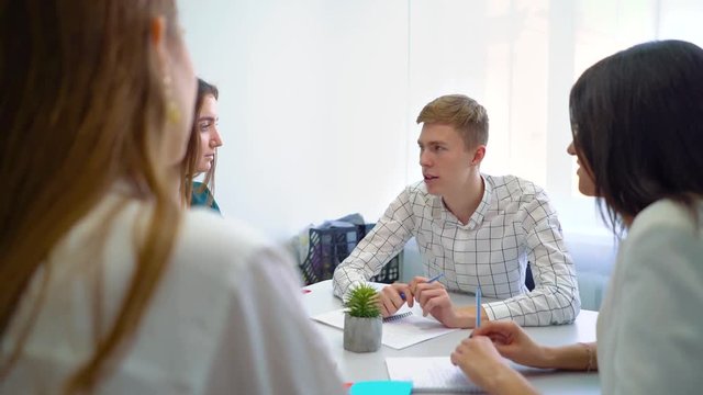 college male and female students having teamwork practice at table. interactivity education, practice, learning, knowledge, cooperation, study concept