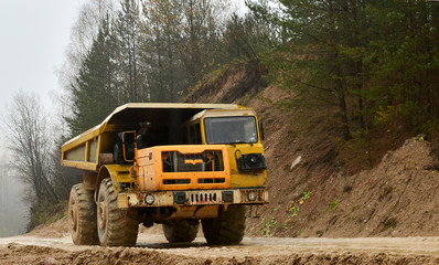 Earth mover loading dumper truck with sand in quarry. Excavator loading sand into dumper truck.Quarry for the extraction of minerals. Large quarry dump truck. Production useful minerals.