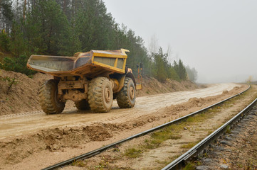 Earth mover loading dumper truck with sand in quarry. Excavator loading sand into dumper truck.Quarry for the extraction of minerals. Large quarry dump truck. Production useful minerals.