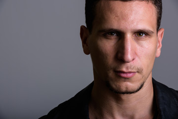 Obraz premium Close up of young muscular Persian man against gray background