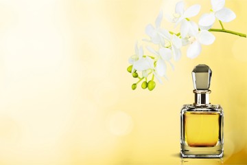 Perfume bottle and flowers on background