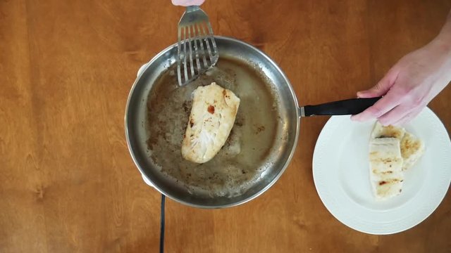 Close up, taking haddock off pan