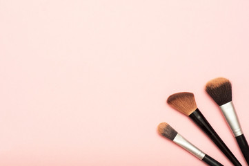 Makeup brushes on a pink background