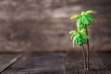 Small toy of palm tree on wooden background
