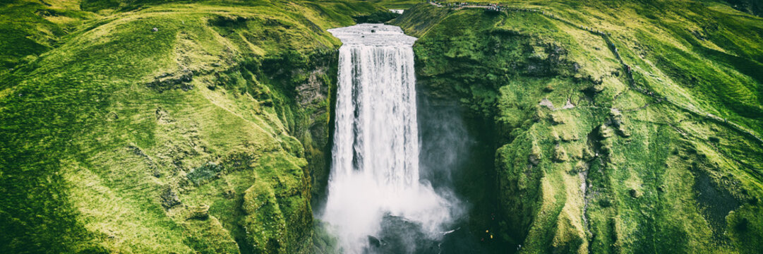 Iceland waterfall Skogafoss banner nature landscape. Panoramic destination in Icelandic famous world landmark tourist attraction on South Iceland. Aerial drone view of top waterfall.