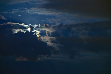 bright moon with glare and clouds in the night sky