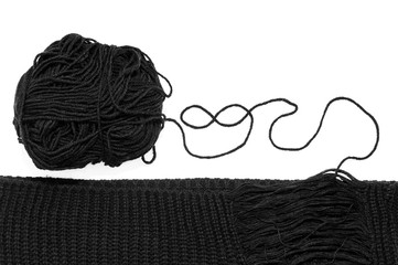 Knitted black stripe and skein of black thread on a white background