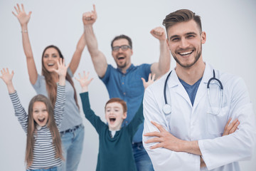 Obraz premium smiling doctor on the background of a happy family